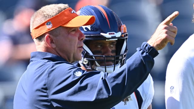 Broncos' QB Russell Wilson speaks with head coach Sean Payton